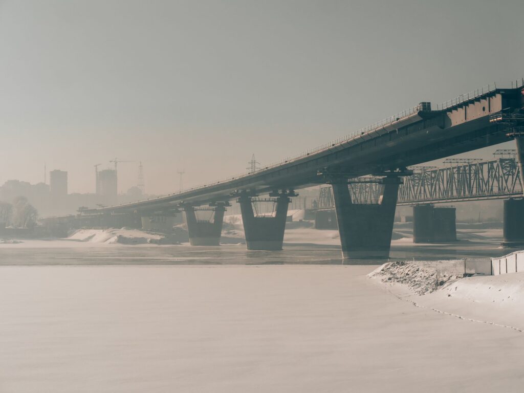 A misty winter view of a steel bridge over the frozen river in Novosibirsk, Russia.