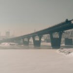 A misty winter view of a steel bridge over the frozen river in Novosibirsk, Russia.