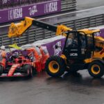 Formula 1 team recovering a race car with a crane at the Las Vegas circuit under rainy conditions.