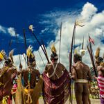 A group of indigenous men in traditional tribal clothing with bows and arrows during a cultural gathering in Papua, Indonesia.