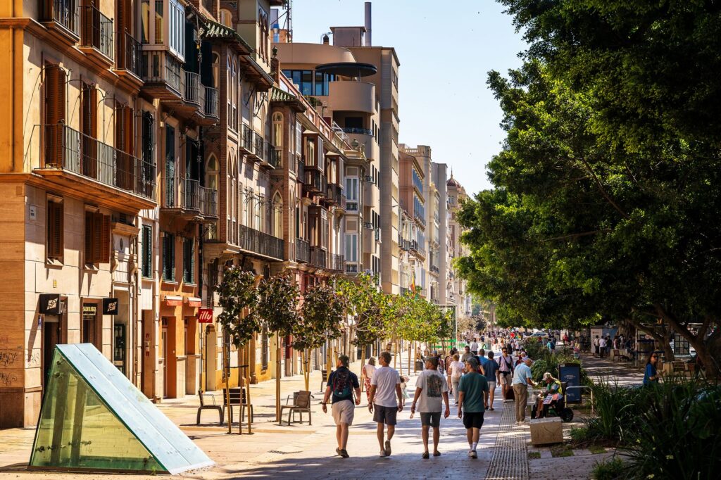 A bustling European street with pedestrians and classic architecture under the summer sun.