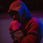 A focused African American man in a hoodie prepares for training in an Ottawa boxing gym.