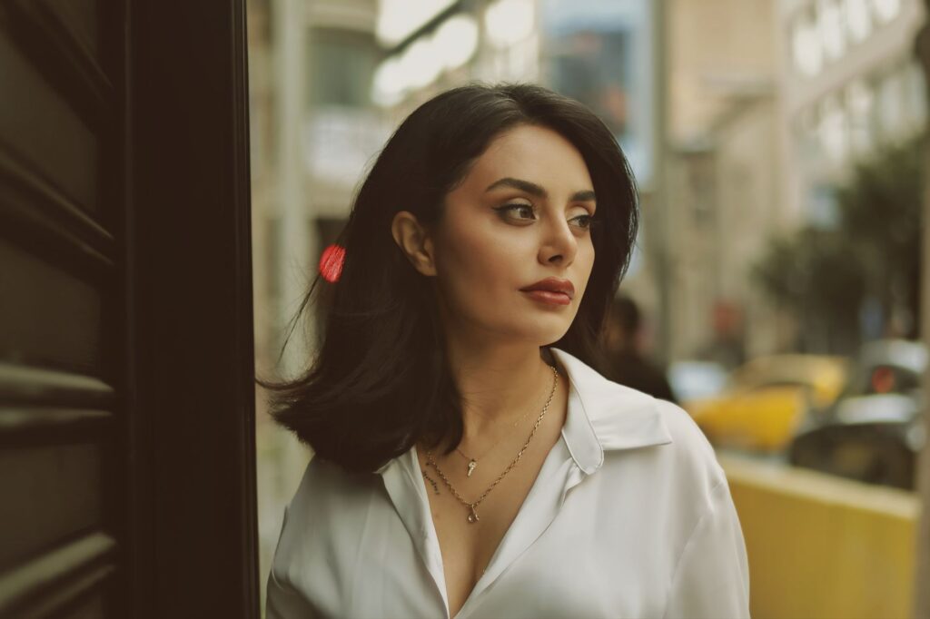 A stylish woman in a city street looking contemplative and elegant.