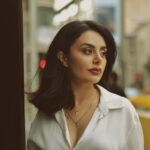 A stylish woman in a city street looking contemplative and elegant.