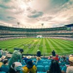 A lively cricket match at Melbourne Cricket Ground with a colorful crowd under a dynamic sky.