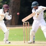 Two cricket players in action on a sunny day, showcasing skillful batting and wicket-keeping.