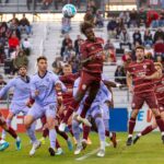 A thrilling moment captured during a competitive soccer match with players in action.