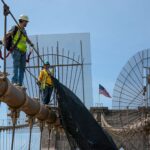 Construction workers performing maintenance on Brooklyn Bridge, NYC.