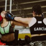Two female boxers engaged in a dynamic match, demonstrating strength and skill.