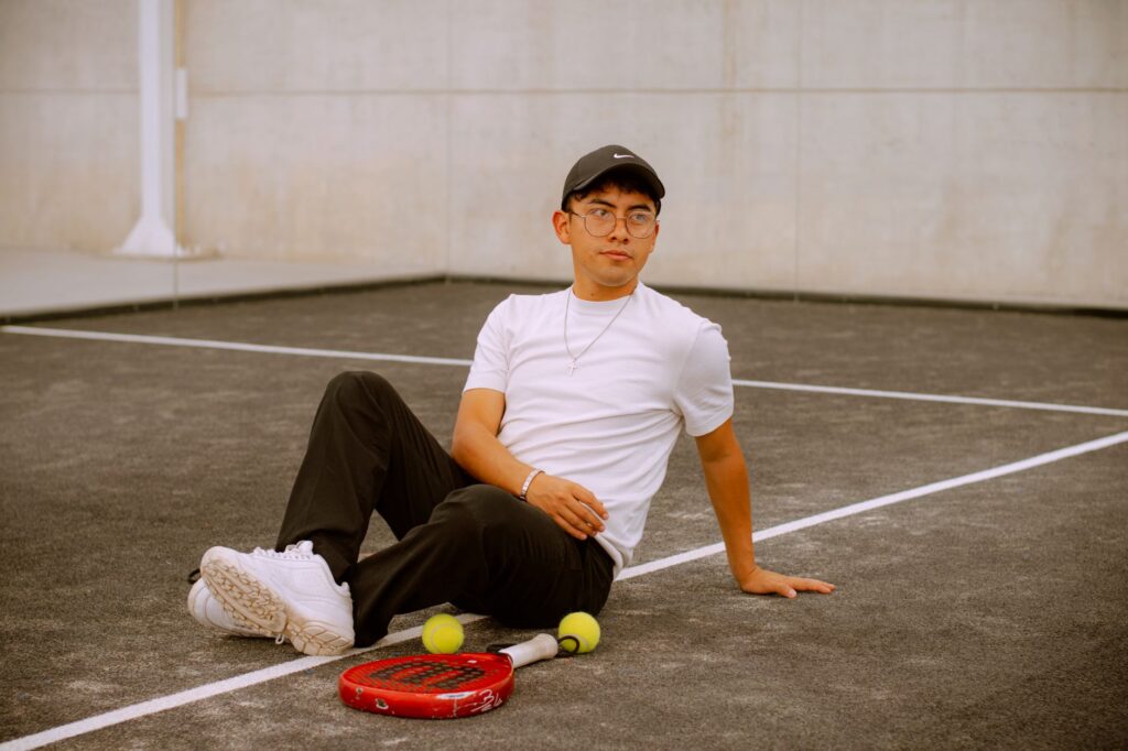Young man in casual attire relaxing on a padel court in Puebla, Mexico.