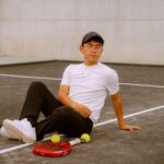 Young man in casual attire relaxing on a padel court in Puebla, Mexico.