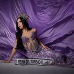 Pageant winner in ornate purple gown with crown, posing elegantly.