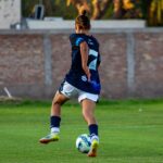 Soccer player in mid-motion on a grassy field, showcasing athletic skill and focus.