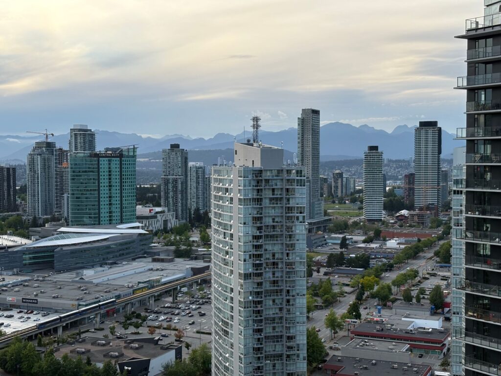 Stunning skyline of Surrey, British Columbia with distant mountains under a twilight sky.