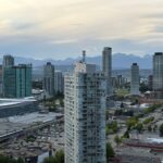 Stunning skyline of Surrey, British Columbia with distant mountains under a twilight sky.