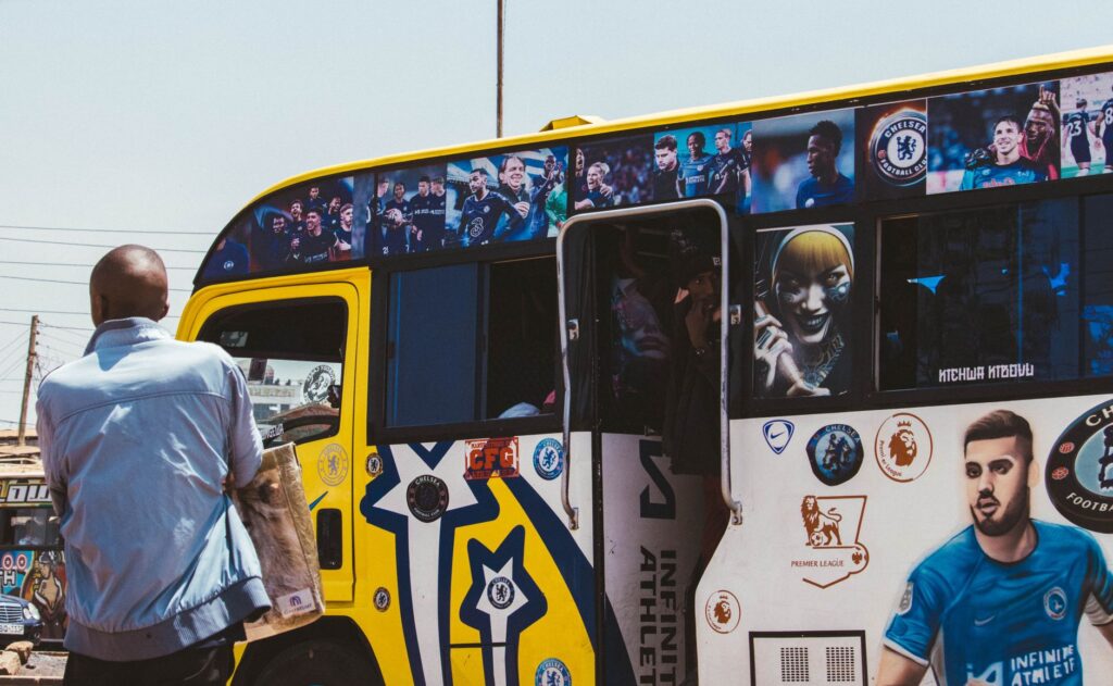 A vibrant matatu bus adorned with football artwork in Nairobi, Kenya, showcasing local culture and sports enthusiasm.