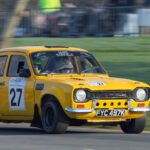 Yellow Ford Escort rally car in action at Weston Park during a motorsport event.