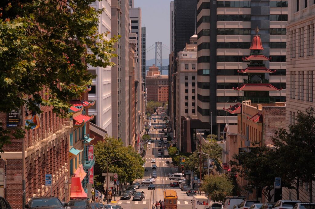 A vibrant view of a San Francisco street leading to the Bay Bridge, showcasing urban architecture and bustling life.