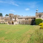 A serene view of Forde Abbey amidst lush greenery on a sunny day.