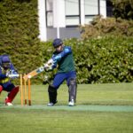 A thrilling moment captured during a cricket game with the batter and wicket-keeper in action.
