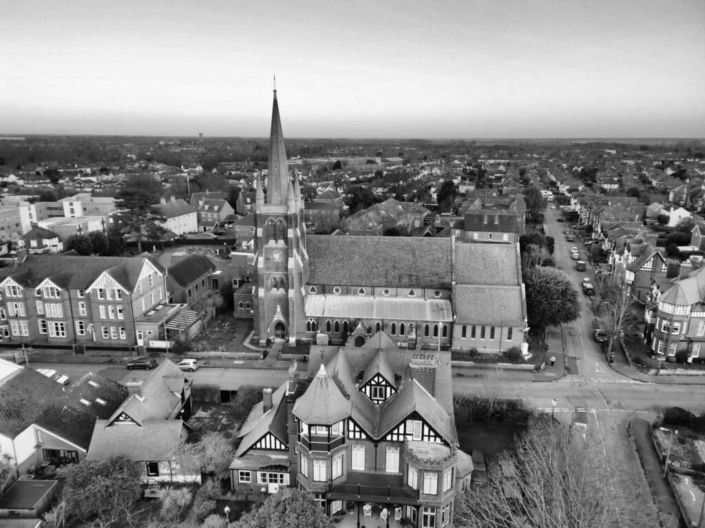 Black and white aerial view of a historic town with a prominent church spire and classic architecture.