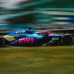 Dynamic shot of a Formula 1 car racing at Interlagos Circuit, São Paulo.