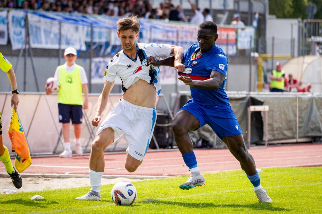 A dynamic capture of two soccer players competing fiercely for possession during a game.