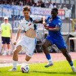 A dynamic capture of two soccer players competing fiercely for possession during a game.