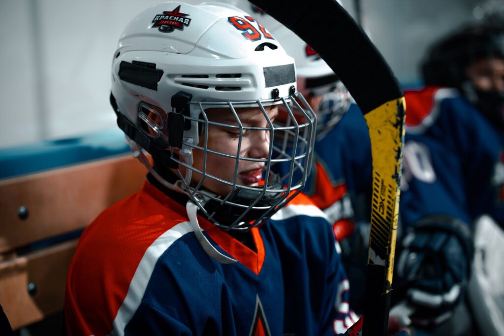 Close-up of a young ice hockey player in full gear, focused and ready for the game.