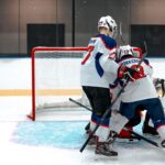 Ice hockey players compete intensely near the goal on a rink.