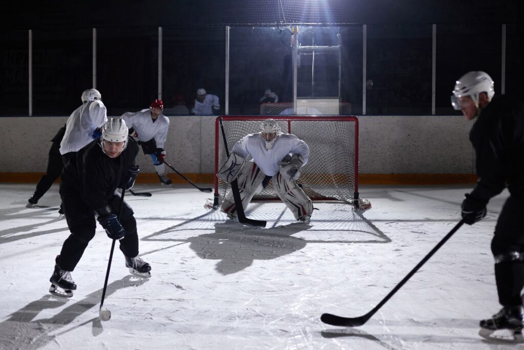 A dynamic moment captured during an ice hockey practice game in an indoor rink.