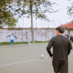 Amateur soccer game with players preparing for a penalty kick on a community field.