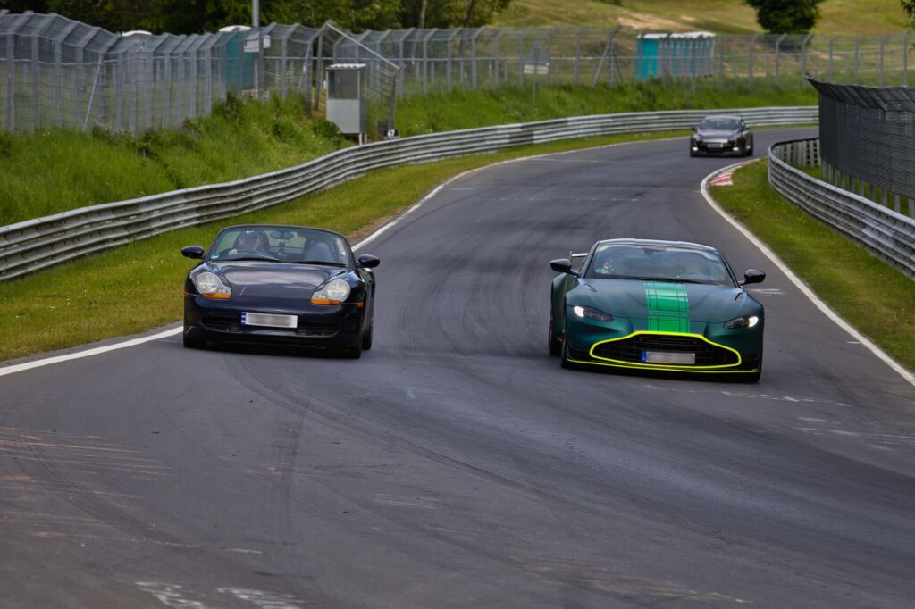 Cars racing on the famous Nurburgring Nordschleife track, showcasing speed and performance.