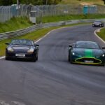 Cars racing on the famous Nurburgring Nordschleife track, showcasing speed and performance.