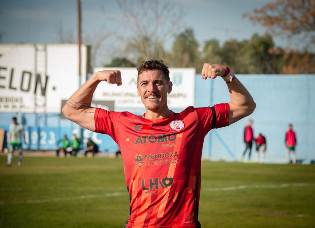 Smiling football player flexing muscles in Mendoza, Argentina.