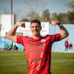 Smiling football player flexing muscles in Mendoza, Argentina.