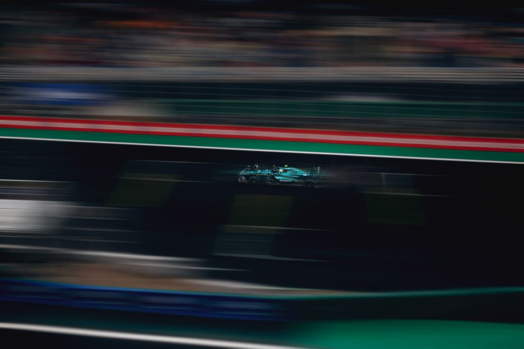 Blurred motion of a racing car speeding on a track during a competitive race.