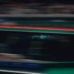 Blurred motion of a racing car speeding on a track during a competitive race.