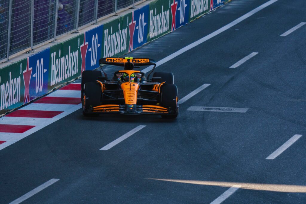 A Formula 1 racing car speeding along the Baku City Circuit during a race event.