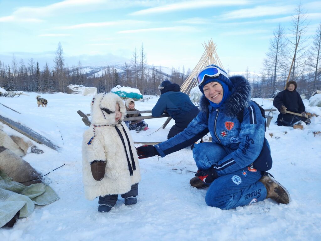 Family dressed in winter clothing, enjoying snow in Yamal-Nenets Autonomous Okrug, Russia.