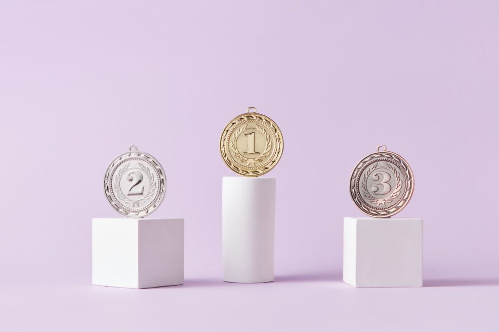 Medals on a podium against a soft pastel background, ideal for awards themes.