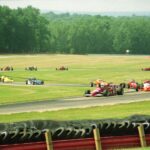 A thrilling outdoor car race featuring colorful formula cars speeding around a track.