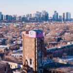 Captivating aerial view of Saint-Henri neighborhood with Montreal skyline in the background.