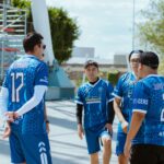 Group of young men in blue jerseys discussing strategy outdoors in Puebla, Mexico.