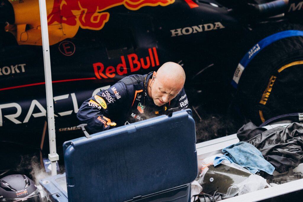 Intense moment as a Formula 1 pit crew member works on a Red Bull racing car during a pit stop.