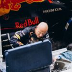 Intense moment as a Formula 1 pit crew member works on a Red Bull racing car during a pit stop.
