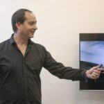 Businessman presenting with remote in office setting, engaging presentation.