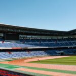 Wide-angle shot of empty Nissan Stadium in Yokohama, Japan, with clear blue skies.