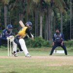 Dynamic cricket action featuring a batsman playing a shot in a lush outdoor setting.