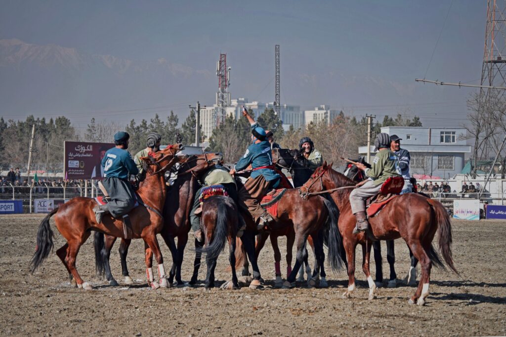 Energetic scene of a traditional Buzkashi game with men on horseback in Kabul, Afghanistan.